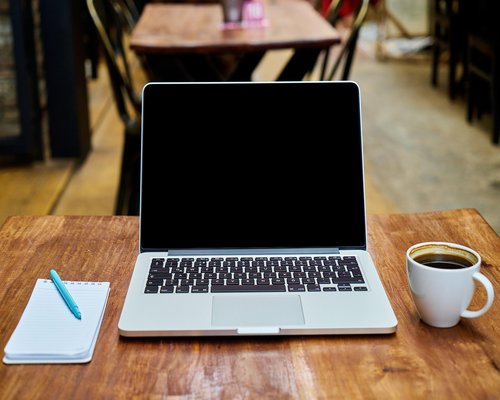 An open notebook on a rustic table highlighting a workspace setup